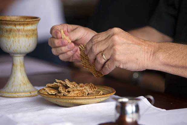 Episcopal priest Buck Belmore prepares consecrated bread for communion during an inaugural pub church service at the Atomic, 917 East Fremont Street, in downtown Las Vegas Sunday, Sept. 8, 2013.