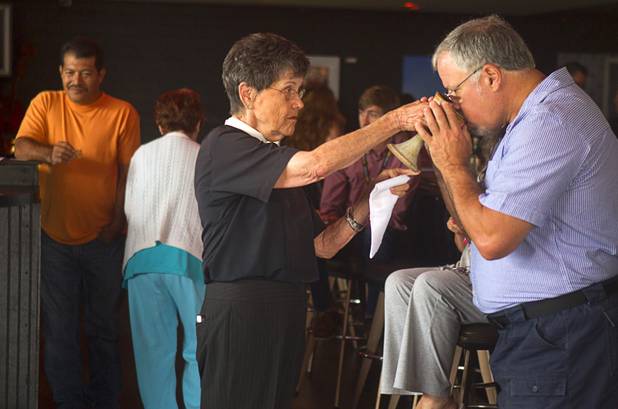 Douglas Vavra of Chicago receives communion from Deacon Bonnie Polley during an inaugural pub church service at the Atomic, 917 East Fremont Street, in downtown Las Vegas Sunday, Sept. 8, 2013.