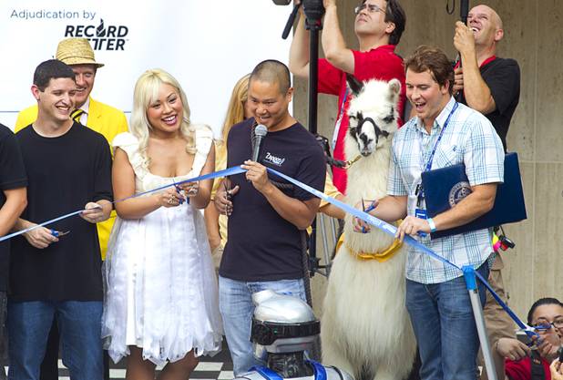 Zappos CEO Tony Hsieh, center, gives a count down for a ribbon cutting during the grand opening ceremony for the Zappos headquarters in the old city hall building downtown Monday, Sept. 9, 2013. According to RecordSetter, a record was set for the largest number of people (1,577 people) to cut a grand opening ribbon at the same time.