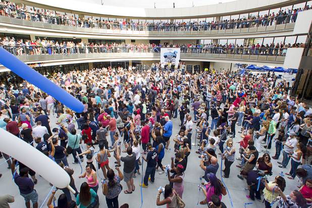 Zappos employees and guests celebrate after cutting a continuous one-mile ribbon during the grand opening ceremony for the Zappos headquarters in the old city hall building downtown Monday, Sept. 9, 2013. According to RecordSetter, a record was set for the largest number of people (1,577 people) to cut a grand opening ribbon at the same time.