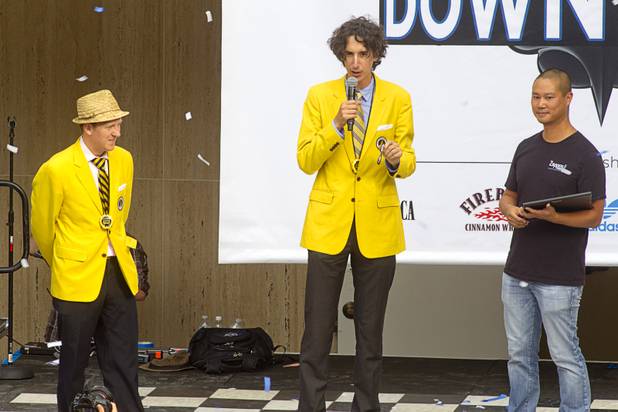 Corey Henderson, left, and Dan Rollman, founders of RecordSetter, give a record recognition to Zappos CEO Tony Hsieh during the grand opening ceremony for the Zappos headquarters in the old city hall building downtown Monday, Sept. 9, 2013. According to RecordSetter, a record was set for the largest number of people (1,577 people) to cut a grand opening ribbon at the same time.