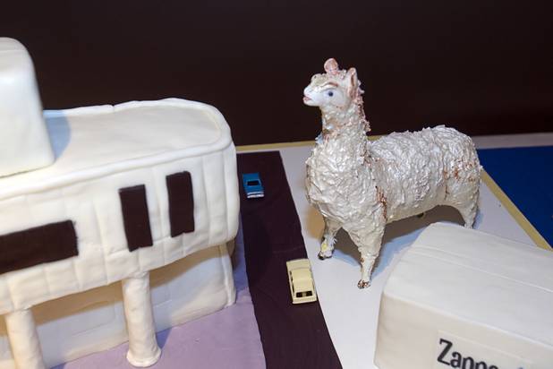 A llama figure is shown by a cake in the shape of  the new Zappos headquarters (the old city hall building) at Zappos Monday, Sept. 9, 2013.