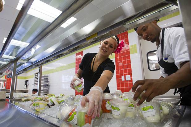 Kaylee D'Amora and Joe Shellmire, lead cook, stock fresh snacks in the Bistro cafeteria at the Zappos headquarters in the old city hall building downtown Monday, Sept. 9, 2013. The downtown headquarters officially opened Monday.