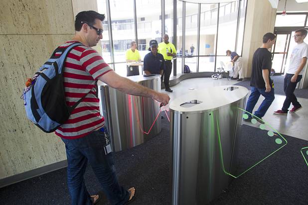 An employee uses his badge to go through turnstiles to the office tower at the Zappos headquarters in the old city hall building downtown Monday, Sept. 9, 2013. The downtown headquarters officially opened Monday.