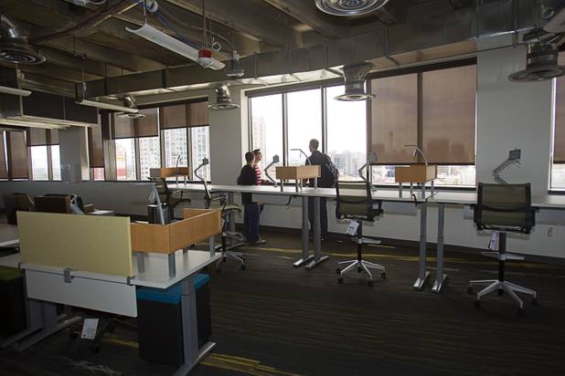 Zappos employees look over downtown from the 10th floor of the Zappos headquarters in the old city hall building downtown Monday, Sept. 9, 2013. The downtown headquarters officially opened Monday.