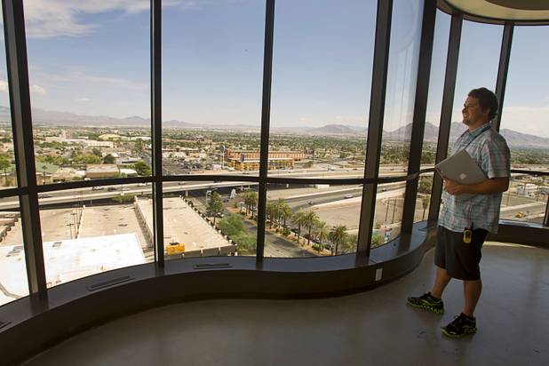 Brad Thomm, sustainability manager for Zappos, looks out a tenth floor window during a tour of the Zappos headquarters in the old city hall building downtown Monday, Sept. 9, 2013. The downtown headquarters officially opened Monday.
