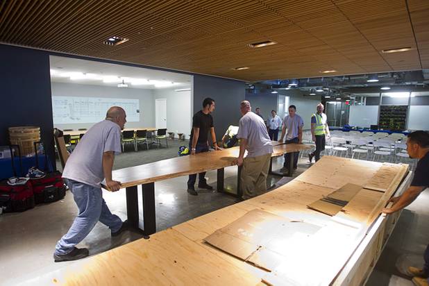 Workers set up a table by the lobby of the Zappos headquarters in the old city hall building downtown Monday, Sept. 9, 2013. The downtown headquarters officially opened Monday.