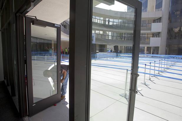 A man washes a glass door prior to the grand opening of the Zappos headquarters in the old city hall building downtown Monday, Sept. 9, 2013. The downtown headquarters officially opened Monday.