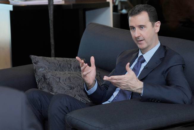 In this Monday, Aug. 26, 2013, file photo released by the Syrian official news agency SANA, Syrian President Bashar Assad gestures as he speaks during an interview with a Russian newspaper, in Damascus, Syria.