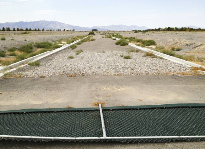 Burson Ranch, a housing development in Pahrump by Beazer Homes, was supposed to have almost 600 homes but only a few dozen were built. Above, a fence is knocked down near an unfinished roadway just inside the main entry of Burson, Monday, Sept. 9, 2013.