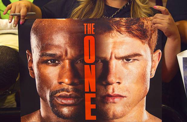 A fan holds a poster as she waits for boxers to arrive at the MGM Grand Tuesday, Sept. 10, 2013. Undefeated boxers Floyd Mayweather Jr. and Canelo Alvarez of Mexico will meet for a WBC/WBA 154-pound title fight at the MGM Grand Garden Arena on Saturday.
