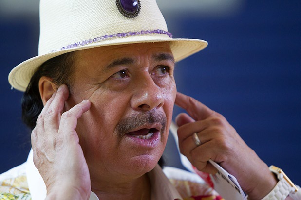 Carlos Santana responds to a question during an interview at the Andre Agassi College Preparatory Academy Tuesday, Sept. 10, 2013. Santana brought a surprise donation of 200 instruments for the school's music students. The instruments came from Hermes Music, LP Music, and PRS guitars.