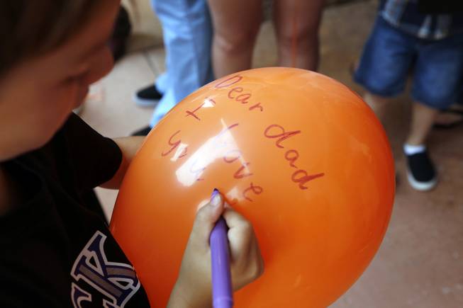 Robert, 7, writes a message to his deceased father for a balloon release at Adam's Place for Grief in Las Vegas on Tuesday, September 10, 2013.