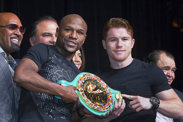 Undefeated boxers Floyd Mayweather Jr., left, and Canelo Alvarez of Mexico pose with a WBC super welterweight belt during a news conference at the MGM Grand Wednesday, Sept. 11, 2013. Mayweather and Alvarez will meet for a WBC/WBA 154-pound title fight at the MGM Grand Garden Arena on Saturday.