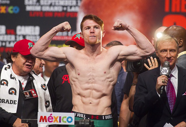 Canelo Alvarez of Mexico flexes on the scale during an official weigh-in at the MGM Grand Garden Arena Friday Sept. 13, 2013. Alvarez will face Floyd Mayweather Jr.in a WBC/WBA 154-pound title fight at the arena Saturday.