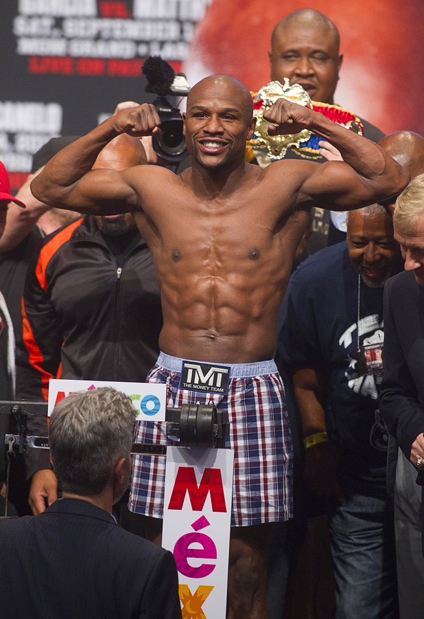 Floyd Mayweather Jr.flexes on the scale during an official weigh-in at the MGM Grand Garden Arena Friday Sept. 13, 2013. Mayweather will face Canelo Alvarez of Mexico in a WBC/WBA 154-pound title fight at the arena Saturday.