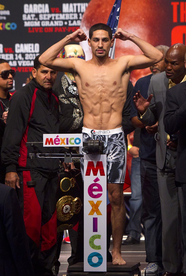 WBC/WBA junior welterweight champion Danny Garcia flexes on the scale during an official weigh-in at the MGM Grand Garden Arena in Las Vegas, Nevada,  September 13, 2013. Garcia will defend his titles against Lucas Matthysse of Argentina at the arena Saturday.