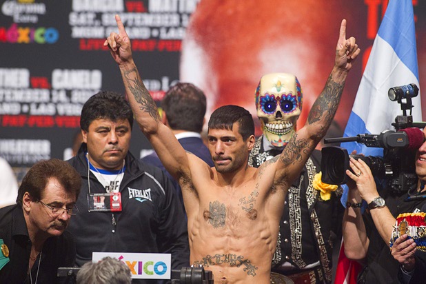 Boxer Lucas Matthysse of Argentina poses on the scale during an official weigh-in at the MGM Grand Garden Arena Friday Sept. 13, 2013. Matthysse will challenge WBC/WBA junior welterweight champion Danny Garcia for his titles at the arena Saturday.