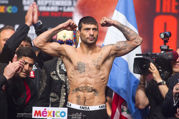 Boxer Lucas Matthysse of Argentina flexes on the scale during an official weigh-in at the MGM Grand Garden Arena Friday Sept. 13, 2013. Matthysse will challenge WBC/WBA junior welterweight champion Danny Garcia for his titles at the arena Saturday.