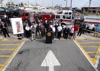 New Jersey Gov. Chris Christie, center, talks during a news conference the morning after a massive fire burned a large portion of the Seaside Park boardwalk, Friday, Sept. 13, 2013, in Seaside Park, N.J. The fire, which apparently started in an ice cream shop and spread several blocks, hit the recently repaired boardwalk, which was damaged last year by Superstorm Sandy. There were no reports of any injuries.