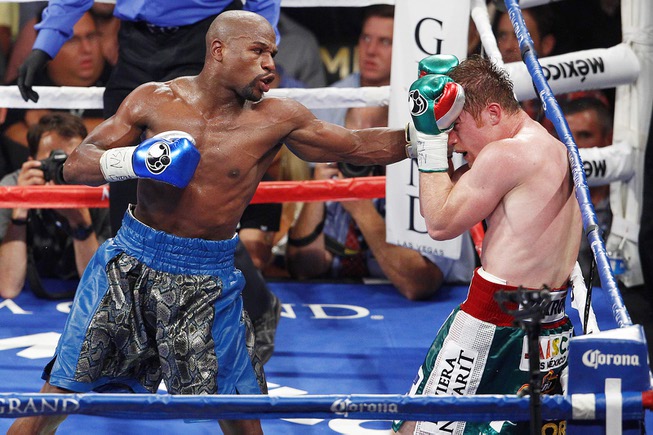 Floyd Mayweather hits Canelo Alvarez with a left during their ...
