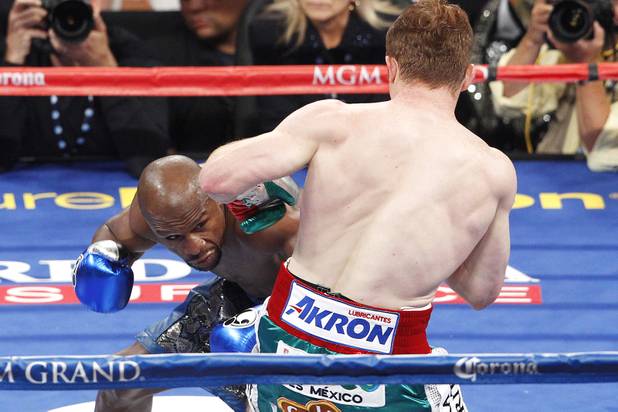Floyd Mayweather ducks a shot by Canelo Alvarez during their super welterweight title fight Saturday, Sept. 14, 2013 at the MGM Grand Garden Arena. Mayweather won the fight with a majority decision.