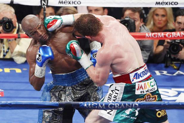 Floyd Mayweather takes a shot from Canelo Alvarez during their super welterweight title fight Saturday, Sept. 14, 2013 at the MGM Grand Garden Arena. Mayweather won the fight with a majority decision.