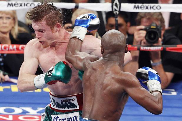 Floyd Mayweather hits Canelo Alvarez with a left during their super welterweight title fight Saturday, Sept. 14, 2013 at the MGM Grand Garden Arena. Mayweather won the fight with a majority decision.