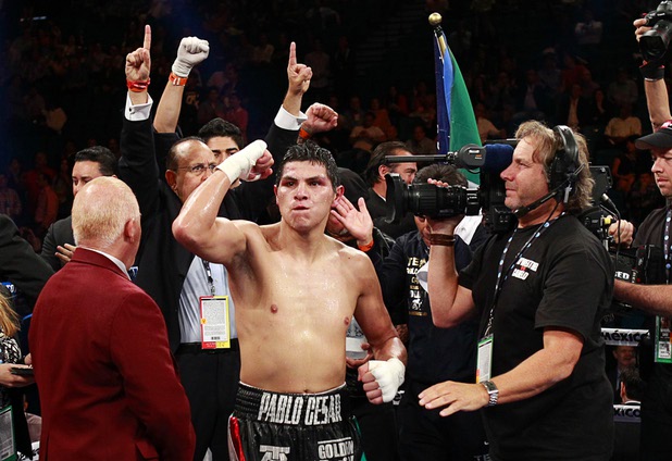Pablo Cesar Cano, center, of Mexico celebrates a spit decision victory over Ashley Theophane of England during a welterweight fight at the MGM Grand Garden Arena in Las Vegas, Nevada, September 14, 2013.
