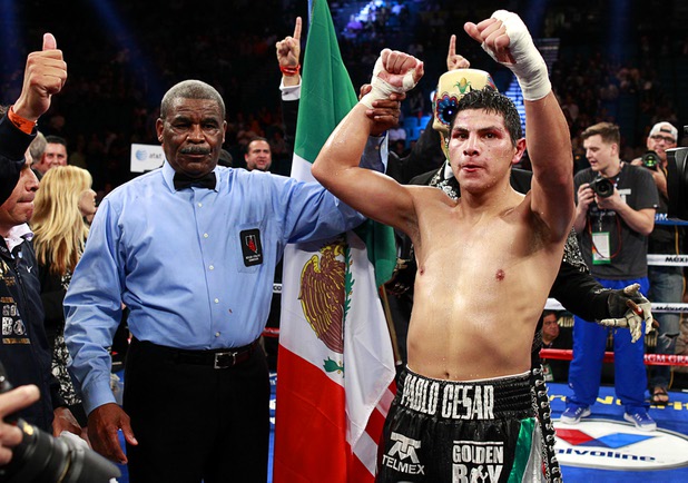 Pablo Cesar Cano, right, of Mexico celebrates a spit decision victory over Ashley Theophane of England during a welterweight fight at the MGM Grand Garden Arena in Las Vegas, Nevada, September 14, 2013. Referee Robert Byrd is at left.