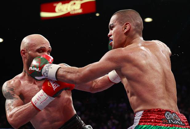 Ishe Smith, left, takes a punch from Carlos Molina of Mexico during their title fight at the MGM Grand Garden Arena Saturday, Sept. 14, 2013.