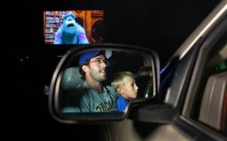 Andrew Whitlock, 34, and his son, Evan, watch the movie, 
