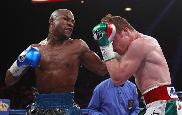 Floyd Mayweather Jr. punches at WBC/WBA 154-pound champion Canelo Alvarez during their title fight at the MGM Grand Garden Arena Saturday, Sept. 14, 2013.