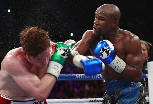 WBC/WBA 154-pound champion Canelo Alvarez, left, takes a punch from Floyd Mayweather Jr. at the MGM Grand Garden Arena Saturday, Sept. 14, 2013.