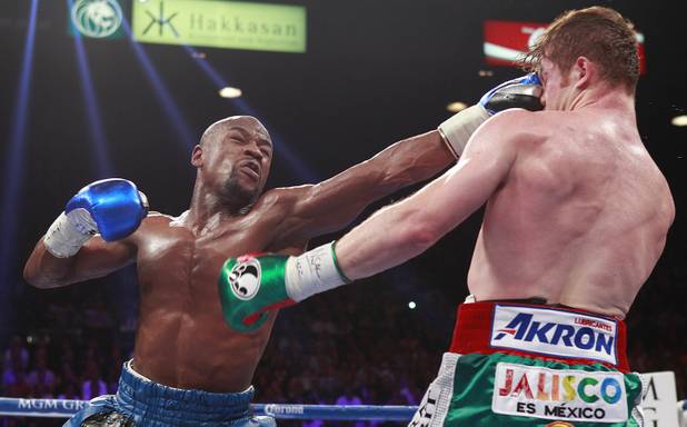 Floyd Mayweather Jr. connects on WBC/WBA 154-pound champion Canelo Alvarez during their title fight at the MGM Grand Garden Arena Saturday, Sept. 14, 2013.