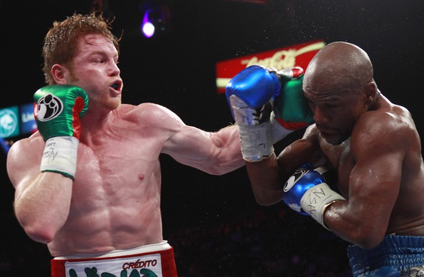 WBC/WBA 154-pound champion Canelo Alvarez, left, punches at Floyd Mayweather Jr. at the MGM Grand Garden Arena Saturday, Sept. 14, 2013.