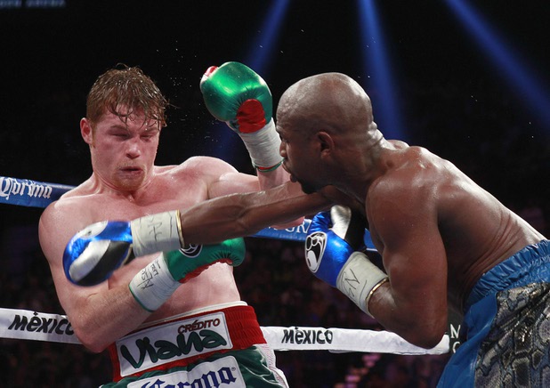Canelo Alvarez, left, takes a punch from Floyd Mayweather Jr. at the MGM Grand Garden Arena Saturday, Sept. 14, 2013.