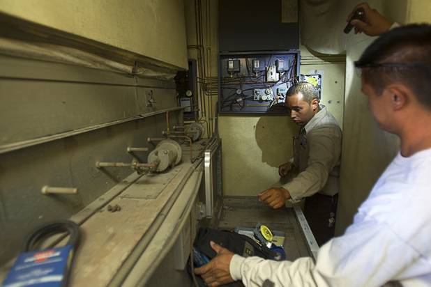 Stephen Molina, center, and Tadone Phengrasamee, HVAC technicians for the Clark County School District, prepare to replace a mechanical timer at Rex Bell Elementary School Tuesday, Sept. 17, 2013. As the effects of the recession continue to affect school operations and deferred maintenance costs continue to rise, the CCSD is finding it difficult to maintain school facilities.