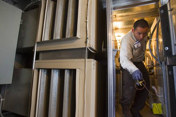 In this 2013 file photo, Stephen Molina, an HVAC technician for the Clark County School District, makes his way through a narrow passage between air handling units at Cashman Middle School. This year, CCSD officials said the cost of the most pressing repairs in district schools — including fixing air conditioning units — is more than $500 million. 