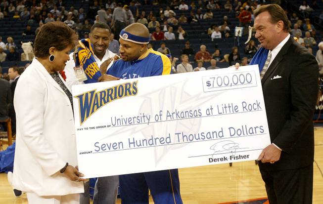 University of Arkansas at Little Rock Athletic Director Chris Peterson, right, accepts a donation from former Trojans basketball player Derek Fisher in 2005. Peterson is one of three finalists for the AD position at UNLV.