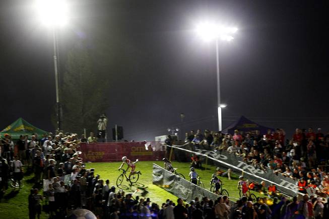 Women leap back on their bikes after negotiating obstacles on a hill during the Cross Vegas cyclocross race Wednesday, Sept. 18, 2013. The women's race was won by Katerina Nash from the Czech Republic.