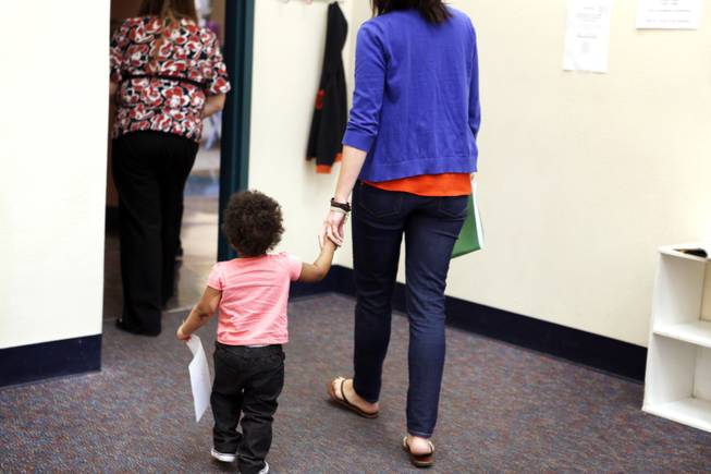 Kisha Earhart, a senior family services specialist with the five-and-under team, walks a child to a supervised visit with her mother and grandmother at the visitation center for Clark County's Department of Family Services on Wednesday, Sept. 18, 2013. Last month, the department removed the three youngsters from the home after a baby also residing there ended up at the hospital with a broken limb and internal injuries.