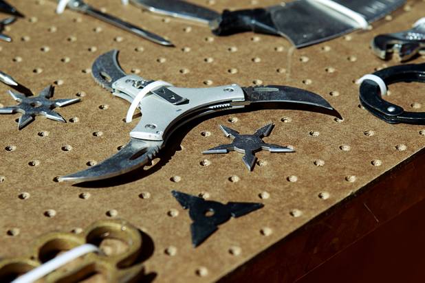 A three-bladed knife and throwing stars are shown in a display of confiscated weapons and prohibited items at the Regional Justice Center Thursday, September 19, 2013.