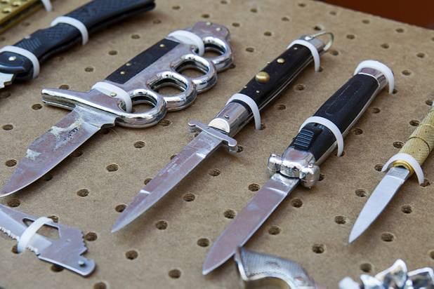 A switchblade and spring-loaded knife are shown in a display of confiscated weapons and prohibited items at the Regional Justice Center Thursday, September 19, 2013.