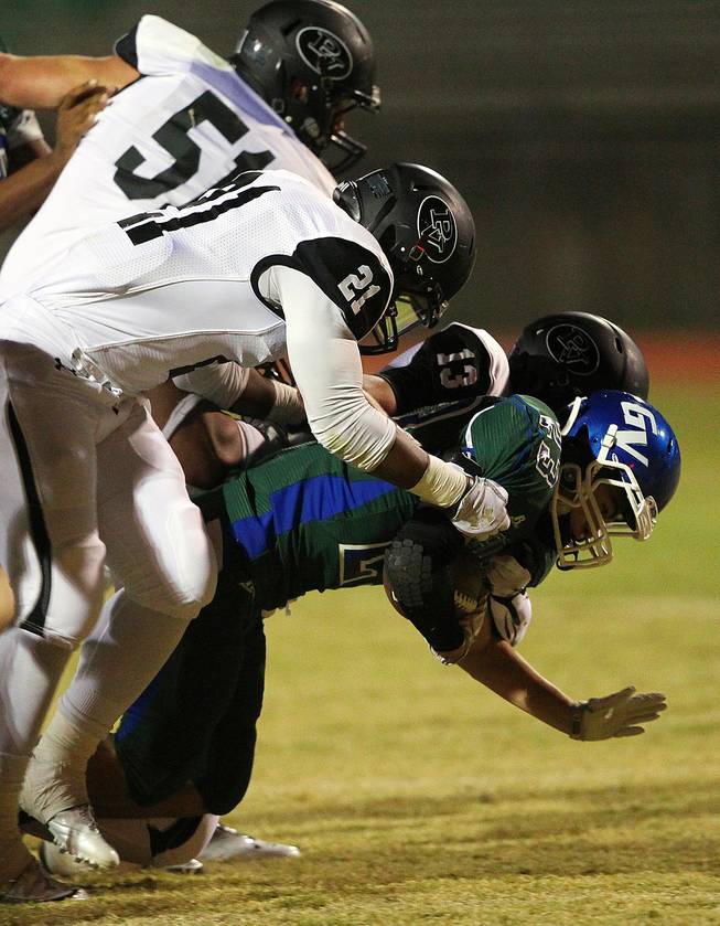 Green Valley running back Albert Lake is taken down by Palo Verde's Griffin Kemp, Jaren Campbell and Jordan Bruner during their game Friday, Sept. 20, 2013. Green Valley won the game in overtime 42-41.