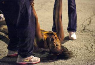 In this Thursday, Sept. 19, 2013, photo, a women becomes emotional near the scene of a shooting at Cornell Square Park in Chicago's Back of the Yard neighborhood that left multiple victims including a 3-year-old boy. Thursday night's attack was the latest violence in a city that has struggled to stop such shootings by increasing police patrols.