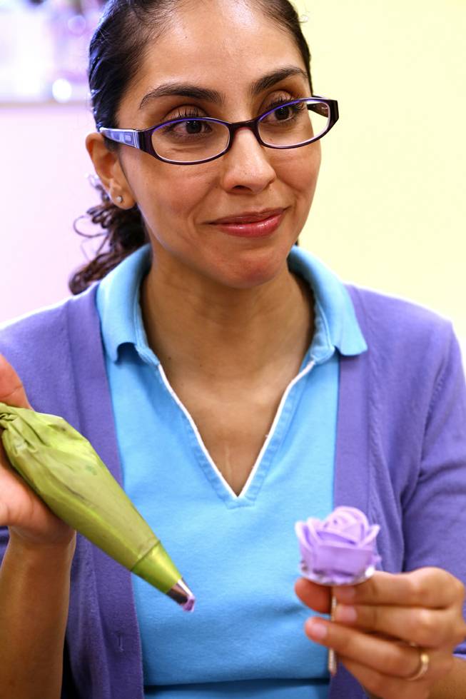 Rocio Quezado prepares a rose from icing during a class taught in Spanish on cupcake decorating at Sweet House in Las Vegas on Monday, September 223, 2013.