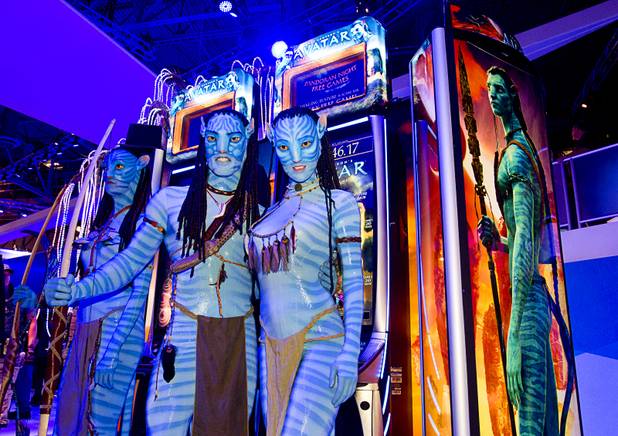 Models portraying Ma'vi warriors from the 2009 "Avatar" movie pose in front of Avatar-themed video slot machines by International Game Technology (IGT) during the G2E convention at the Sands Expo Center Tuesday, Sept. 24, 2013.