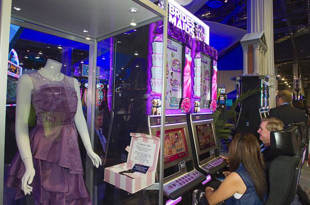 People try out a Bridesmaids video slot machine by International Game Technology (IGT) during the G2E convention at the Sands Expo Center Tuesday, Sept. 24, 2013.