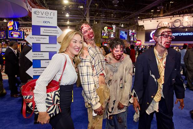 Convention model Sarah Hales poses with zombies during the G2E convention at the Sands Expo Center Tuesday, Sept. 24, 2013.  The zombies were promoting a new "Walking Dead" video slot machine by Aristocrat. The slots are themed after AMC's Walking Dead television drama.